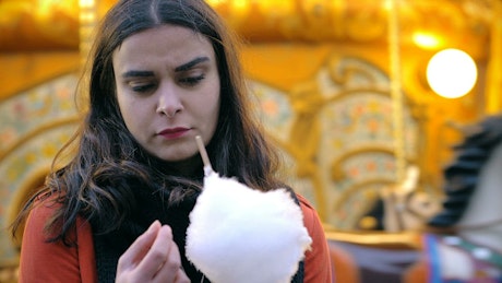 Woman with cotton candy looking upset.