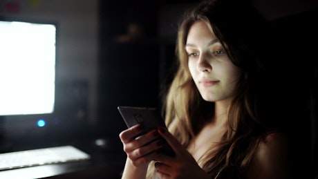Woman with insomnia checks mobile phone.