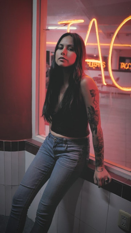Woman with tattoos in a shop window.