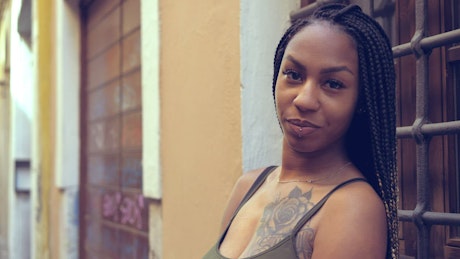 Woman with tattoos on her posing smiling outside.