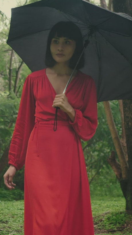 Woman with umbrella in nature in the rain.