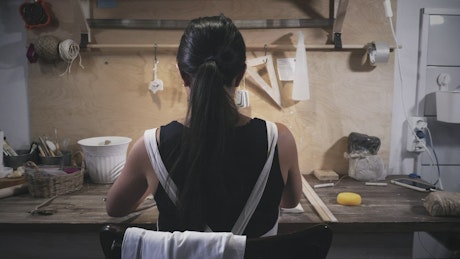 Woman working in pottery workshop.
