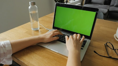 Woman working with a laptop at home.