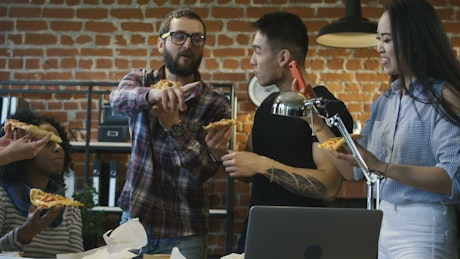 Workers eating pizza in the office