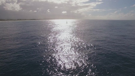 Yacht sailing through golden ripples