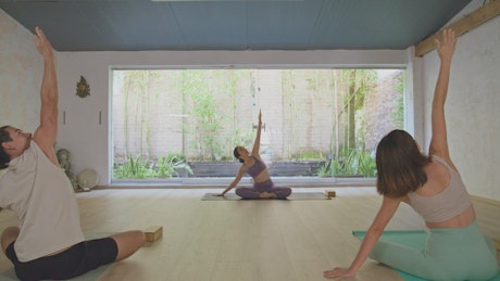 Yoga practice between three people.