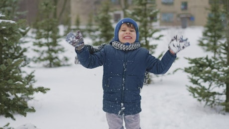 Young boy clapping hands excitedly in the snow.