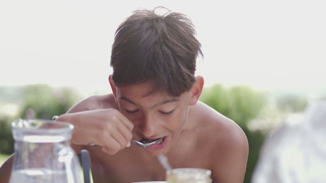 Young boy eating breakfast.