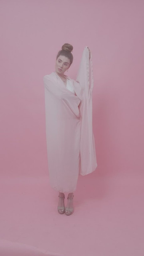 Young female model posing on a pink background