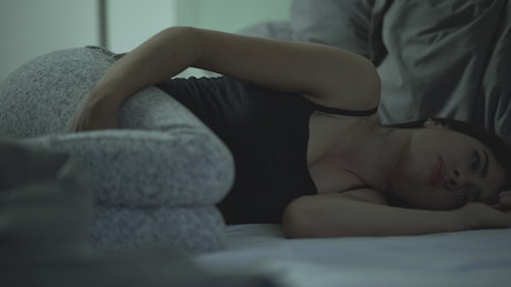 Young grieving woman crying lying in fetal position