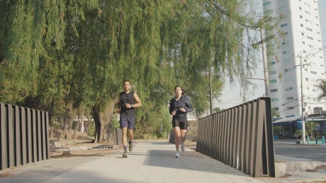 Young man and woman jogging outdoors.