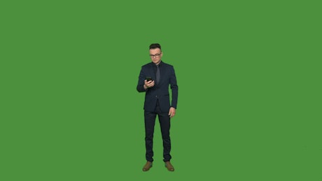 Young man answering a phone call on a green screen.
