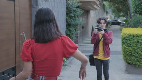 Young Man filming a girl dancing in the street.