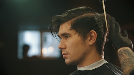 Young man in profile while having his hair cut