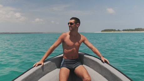 Young man in sunglasses enjoying  a boat trip.
