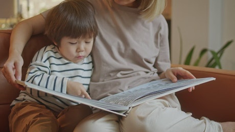 Young mother reading a bedtime story to her son.
