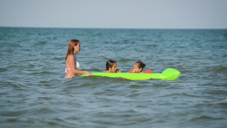 Young mother with her daughters at the sea.
