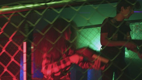 Young people playing laser tag in video game center