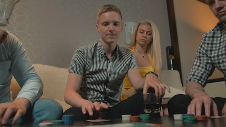 Young people playing poker in a room.