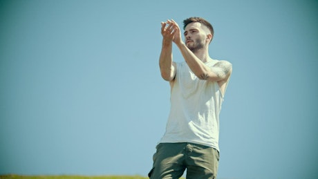 Young stylish man with tattoos in white shirt dancing.