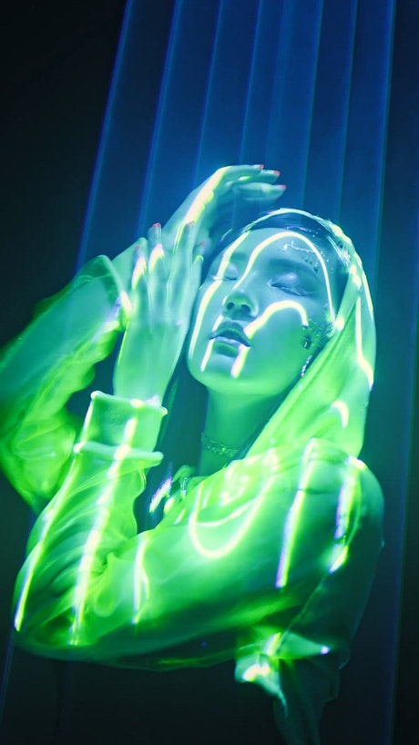 Young woman dancing under neon lights.