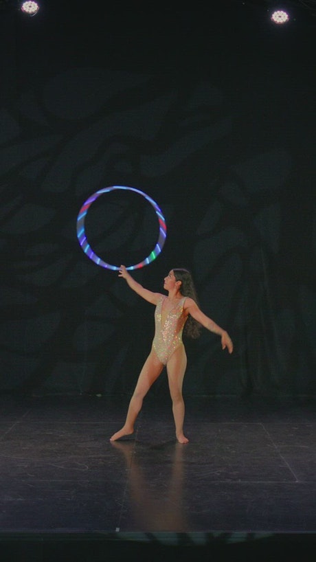 Young woman doing tricks with a hula hoop.