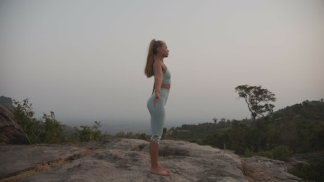 Young woman doing yoga in the mountains.