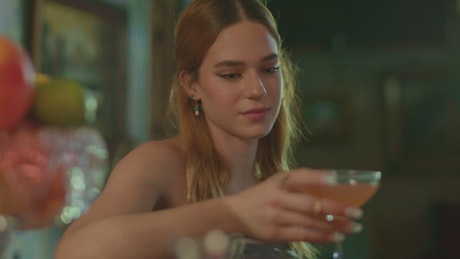 Young woman drinking a margarita in a bar.