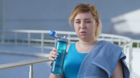 Young woman drinking after running.