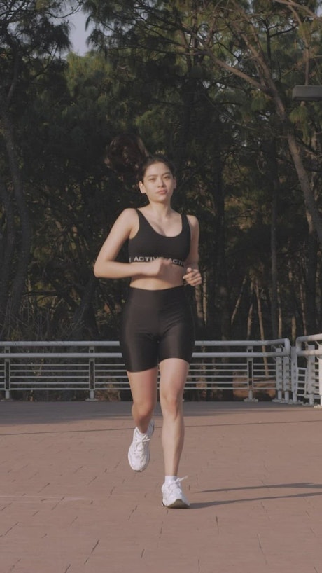 Young woman jogging head-on outdoors.