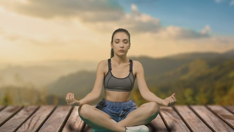 Young woman meditating to align chakras.