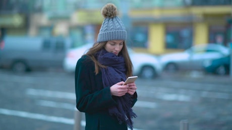 Young woman on the street texting on her phone