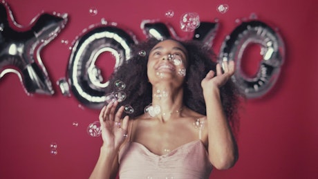 Young woman playing funny and happy with bubbles