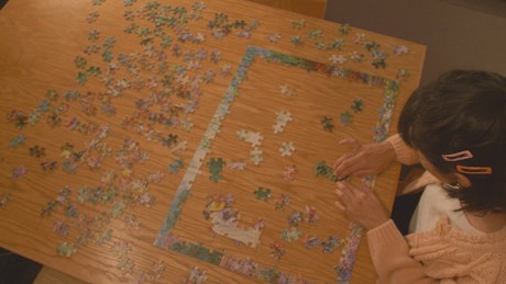 Young woman putting together a puzzle