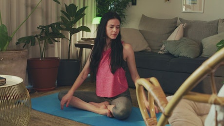 Young woman stretching her body in her living room