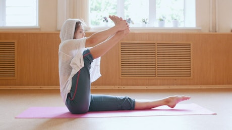 Young woman stretching one of her legs doing yoga.