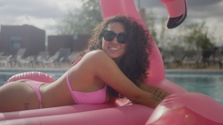 Young woman sunbathing in a bikini at the pool.