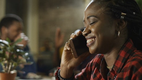 Young woman talking on the phone and smiling.