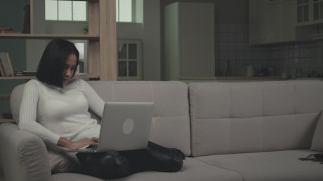 Young woman using laptop in the couch.