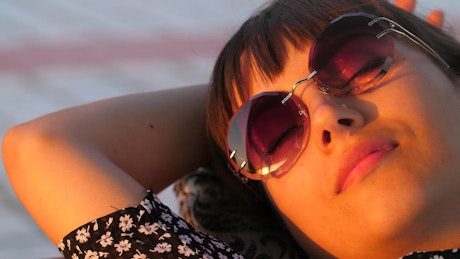 Young woman with glasses resting lying in the sun