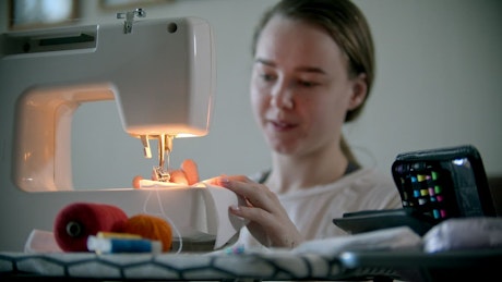 Young woman working on a sewing machine.