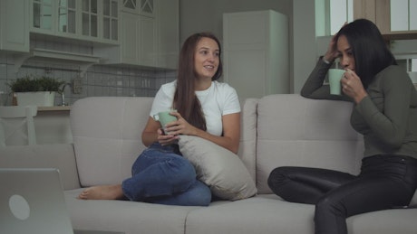 Young women drinking coffee in the living room