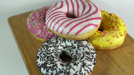 Yummy snack of beautifully decorated donuts with sprinkles.