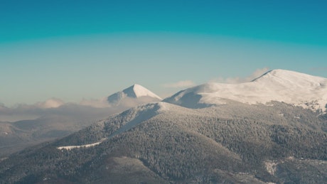 Zoom out of a mountainous area in winter.